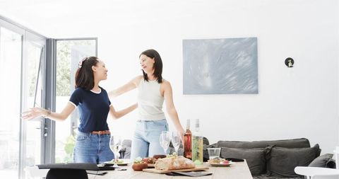 Friends celebrating graduation in bright dining room