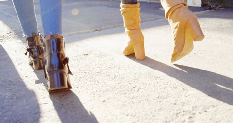 Stylish Women Walking Hand in Hand Under Sunlight - Download Free Stock Images Pikwizard.com