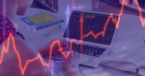Student analyzing stock market data on laptop in modern study room