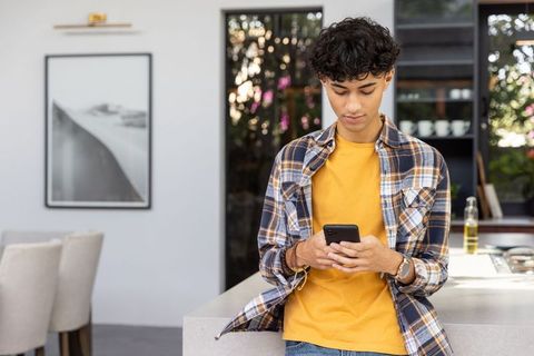 Young adult relaxing casual stylish outfit texting modern home