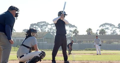 Community Baseball Players Batting, Catching and Pitching on Sunlit Neighborhood Diamond