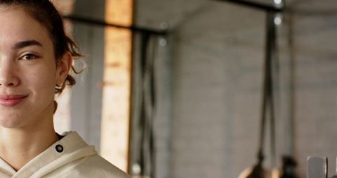 Woman adjusting resistance straps at gym pull-up bar