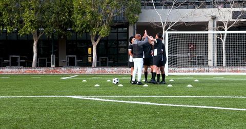 Soccer Team Huddling During Training Session Outdoors