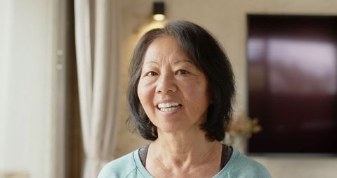 Senior Asian Woman Smiling in Cozy Modern Home Interior