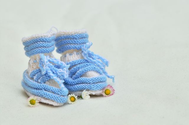 Hand-Knitted Baby Booties with Flowers on White Background - Download Free Stock Photos Pikwizard.com