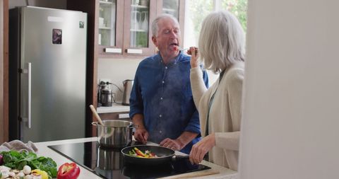 Happy Senior Couple Cooking Together in Modern Home Kitchen