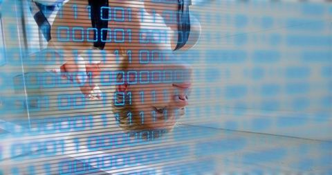 Standing woman reflecting in digital display with blue binary code overlay, tech portrait