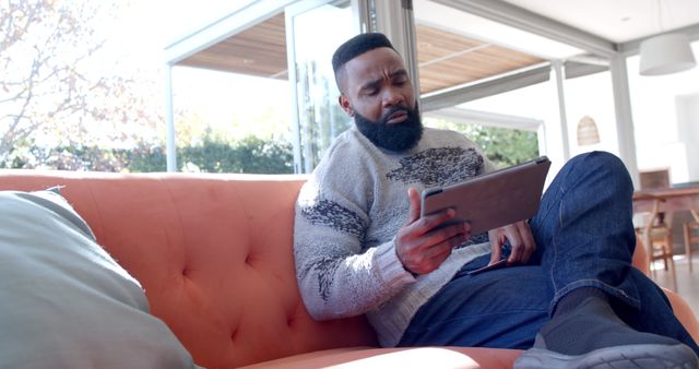 Man Relaxing on Sofa While Using Digital Tablet in Modern Living Room - Download Free Stock Images Pikwizard.com