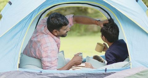 Father and Son Bonding in Cozy Camping Tent Setting