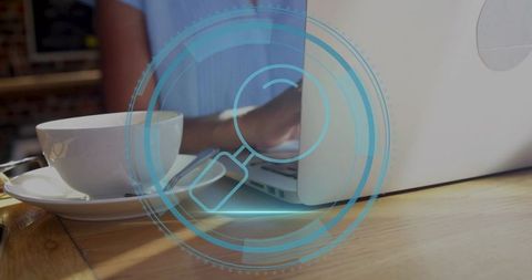 Woman typing on laptop in cafe with coffee and digital hud magnifying overlay