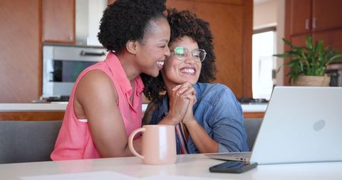 Happy Lesbian Couple Enjoy Leisure Time with Coffee and Laptop