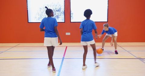 Girls Practicing Basketball Skills in School Gym