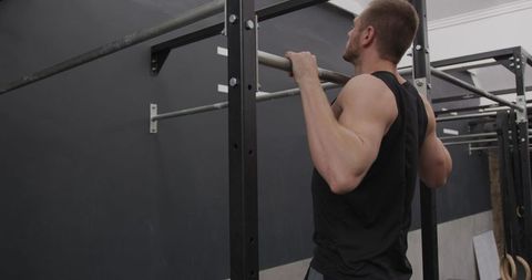 Athletic Man Performing Chin Ups in Gym for Strength Training
