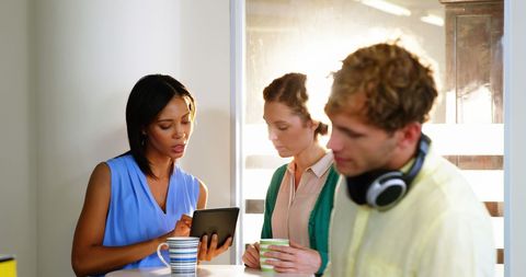 Colleagues Collaborating with Tablet in Modern Office Set-up