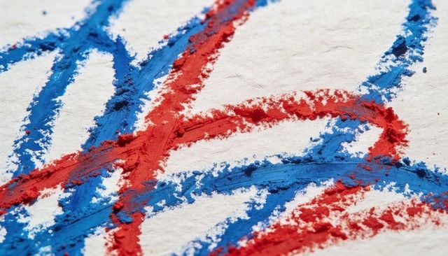Interlocking red and blue pastel strokes on handmade textured paper macro background