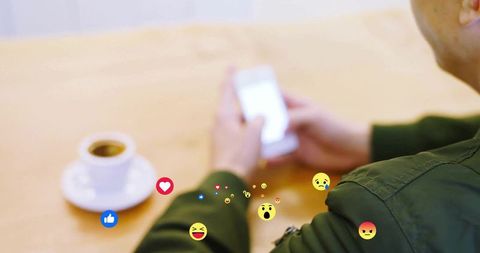 Man engaging with social media reactions at a cozy cafe