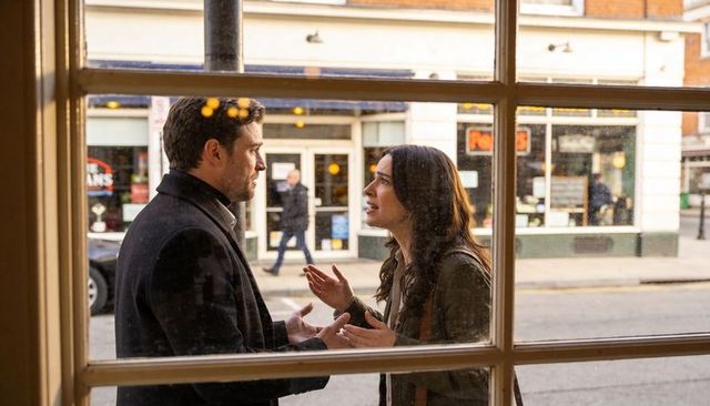 Couple arguing through window frame on urban sidewalk showing heated relationship conflict