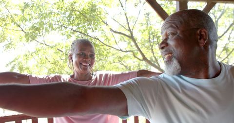Senior Couple Practicing Yoga on Sunny Porch