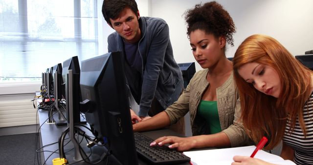 Young students collaborate on a computer task, emphasizing teamwork in education. - Download Free Stock Photos Pikwizard.com