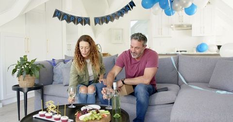 Joyful Birthday Celebration with Mature Couple in Modern Living Room