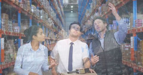 Diverse warehouse workers analyzing data in operations facility