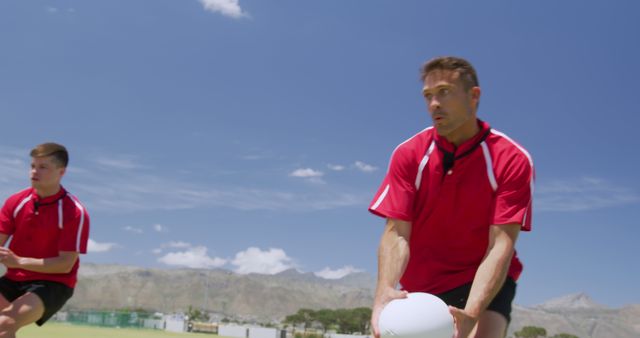 Rugby players practicing on field with mountains in background - Download Free Stock Images Pikwizard.com