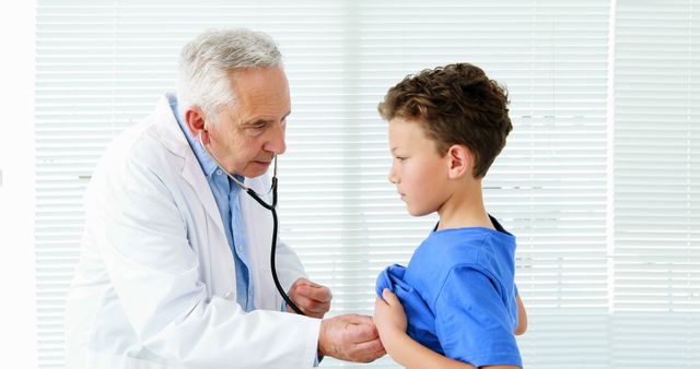 Doctor conducting a chest examination on a young boy in a medical office. Photo is useful for illustrating healthcare services, pediatric care, and medical consultations.