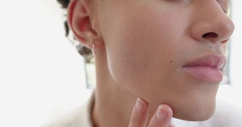 Young Man Inspecting Skin at Home with Natural Light