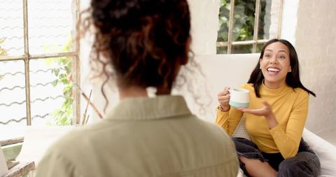 Two Friends Sharing Ideas Over Coffee in Creative Studio