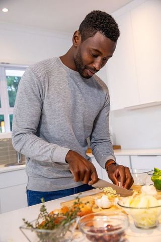 Man Skillfully Chopping Garlic in Modern Kitchen