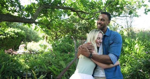 Couple Embracing Joyfully in Lush Greenery Garden