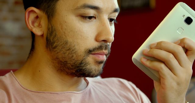 Young Man Using Smartphone Studying Device Screen Closely - Download Free Stock Images Pikwizard.com