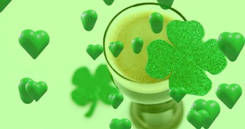 Serving layered green latte with crema, floating glitter shamrock and glossy hearts