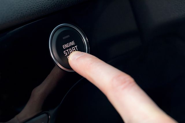 Close-up of a finger pressing the engine start button in a car. Ideal for illustrating modern automotive technology, vehicle convenience features, and advancements in car design. Useful for automotive blogs, car reviews, and technology articles.