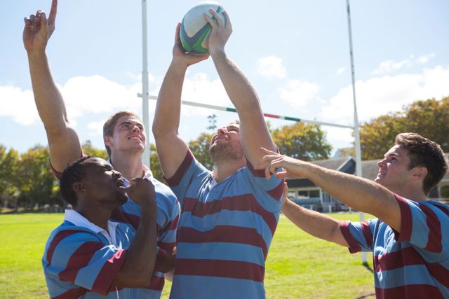 Rugby team celebrating victory on a sunny field, showing teamwork and joy. Ideal for use in sports promotions, team-building materials, and advertisements highlighting success and camaraderie.