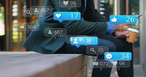 Man checking social media notifications on smartphone while holding coffee on urban bench