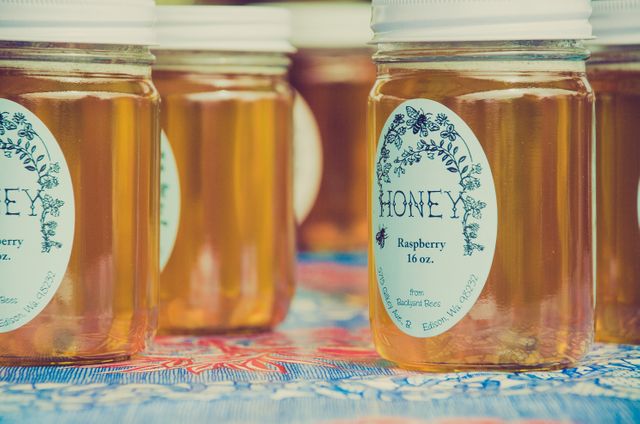Organic Raspberry Honey Jars Display on Colorful Table Cloth - Download Free Stock Photos Pikwizard.com