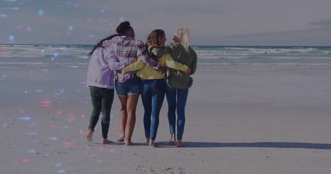 Four Women Walking Together Along Tranquil Sandy Beach