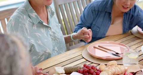 Senior Friends Holding Hands at Outdoor Lunch Gathering - Download Free Stock Images Pikwizard.com