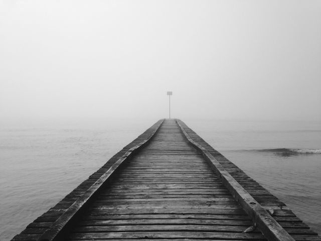 Misty wooden pier stretching into calm ocean - Download Free Stock Images Pikwizard.com