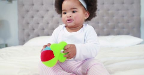 Adorable Baby Playing with Colorful Toy on Bed