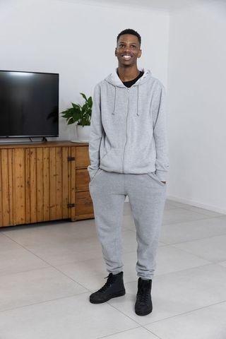 Smiling Man in Grey Sportswear in Contemporary Living Room