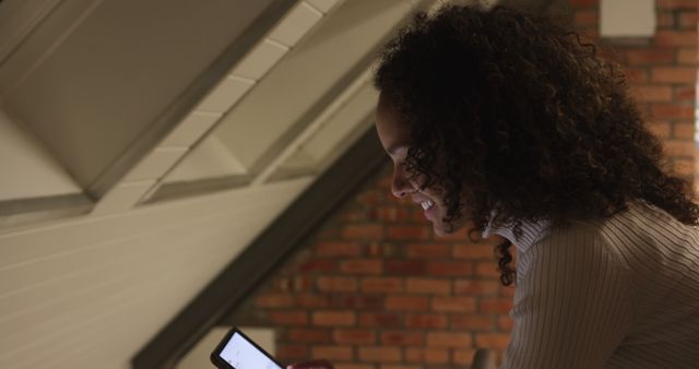 Woman Smiling While Using Smartphone in Cozy Attic - Download Free Stock Images Pikwizard.com