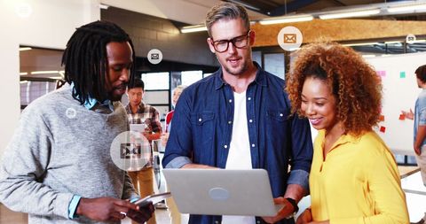 Diverse Colleagues Reviewing Ideas on Laptop in Modern Office