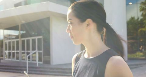 Young Professional Woman Using Smartphone Outdoors with Copy Space