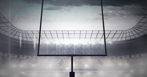 Floodlit Stadium with American Football Goalposts and Cloudy Sky