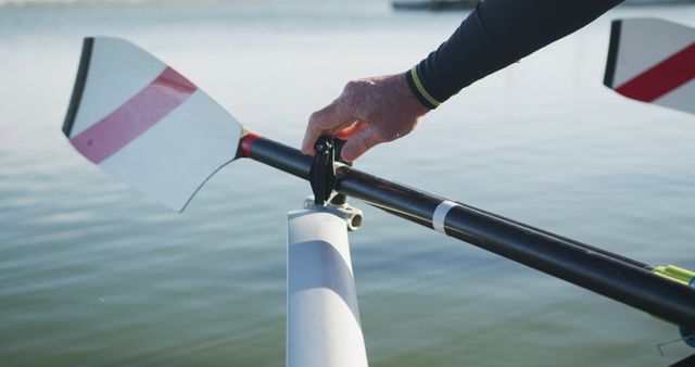 Hand gripping rowing oar on calm lake during practice - Download Free Stock Images Pikwizard.com