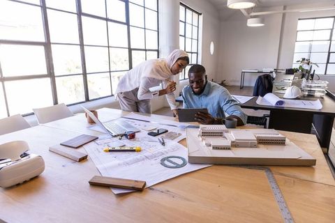 Diverse Architects Collaborating with Tablet in Modern Studio