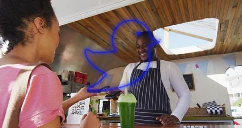 Smiling Barista Receives Payment at Vibrant Juice Bar Kiosk