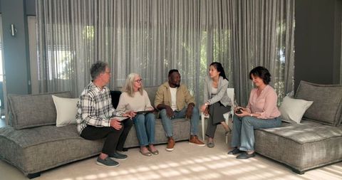 Diverse group therapy session with smiling therapist shaking hands